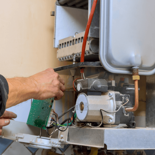 Heating engineer diagnosing and fixing a boiler fault